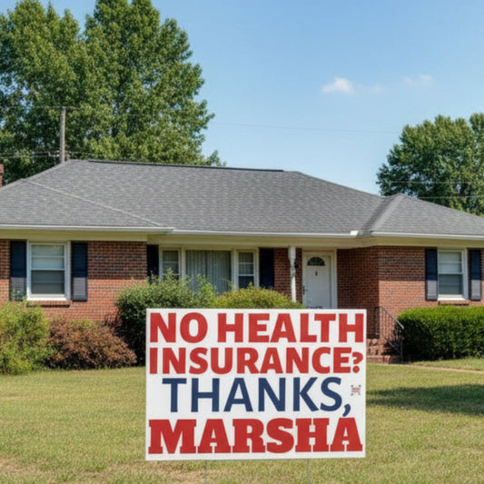 Political protest sign with text 'No health insurance? Thanks, Marsha' on a white background in front of a ranch-style suburban home