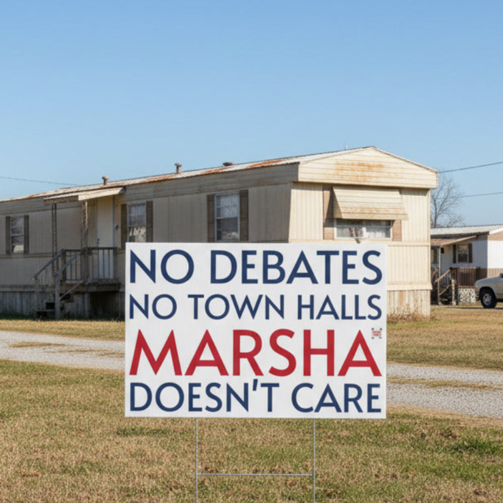 Political sign with text 'No debates, no town halls, Marsha doesn't care' on a white background in front of a single-wide trailer